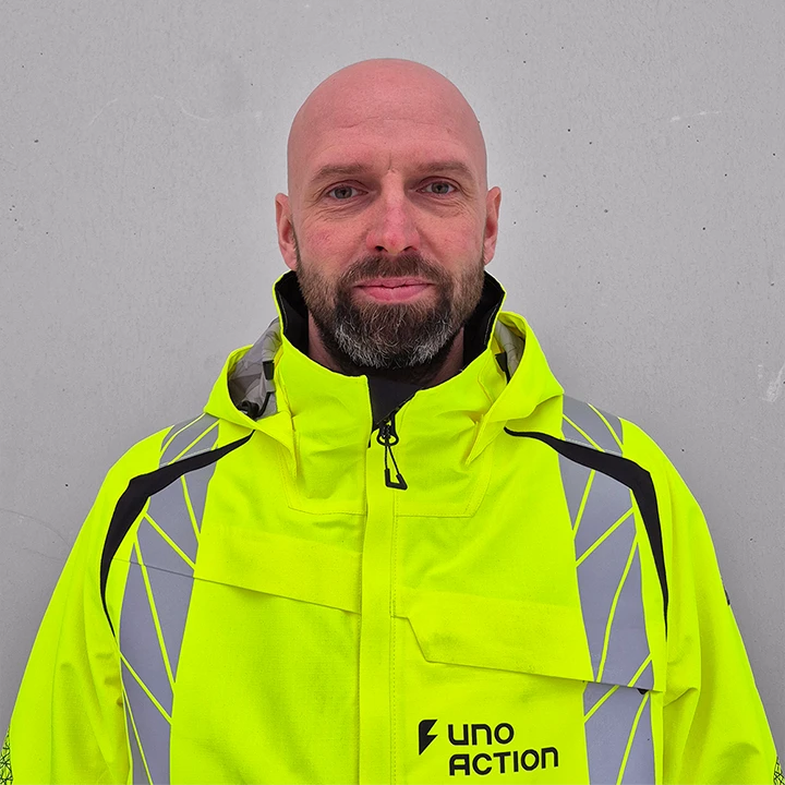 Timo Leppäsen henkilökuva, jossa hän katsoo kameraan Uno Actionin työtakki päällään.